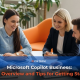 Business team meeting in a modern office discussing Microsoft Copilot Business implementation, used as a banner image for an article on Copilot offers and rollout tips.